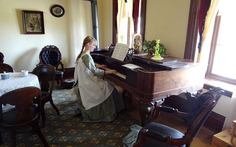 girl playing the piano in historical costume