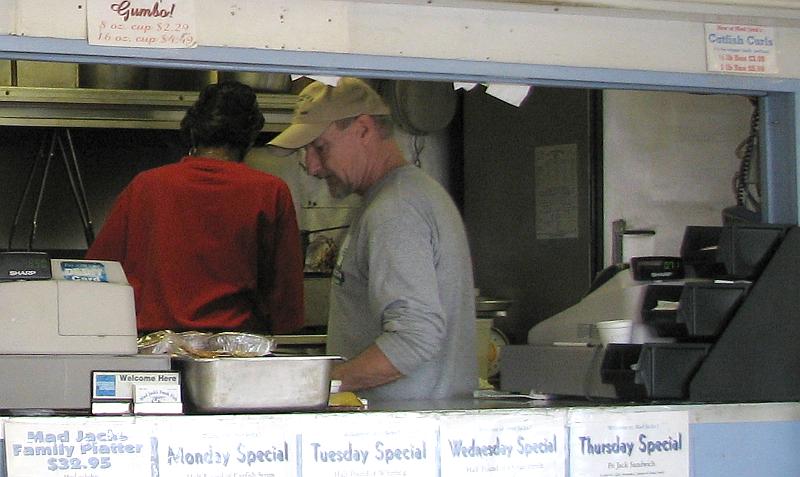 John Reed behind the cooked food counter at Mad Jack's